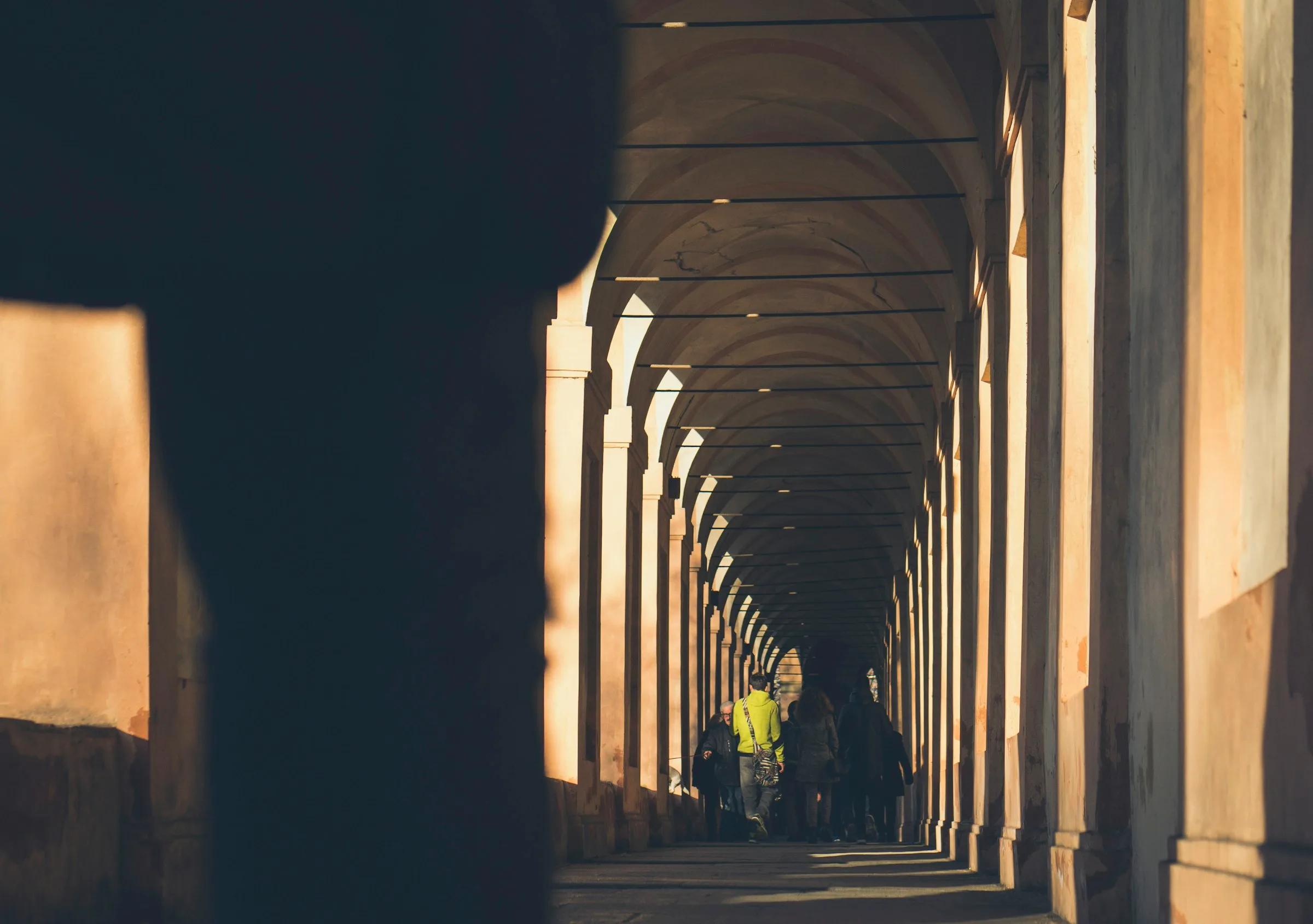Colonnato che si allontana, con la luce del mattino in fondo al portico