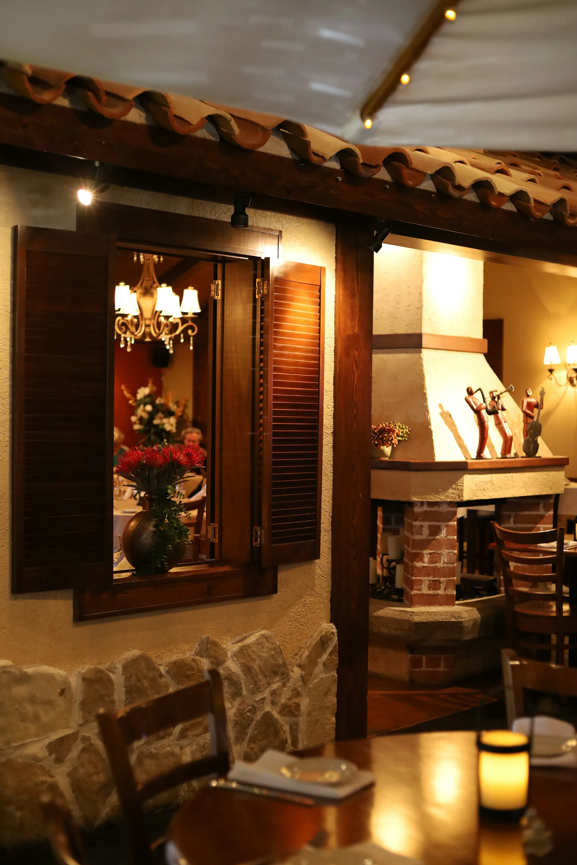 Saletta di una trattoria con il camino acceso e i tavoli apparecchiati